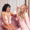 Two women in heart print nightwear eating cake