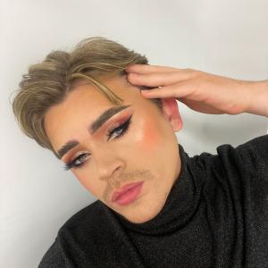 Person in black turtleneck with glamorous make up 