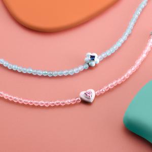 Two Thomas Sabo necklaces on a peachy pink background